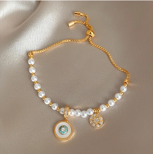 Détail de breloques œil et soleil dorées sur un bracelet perles pour femmes