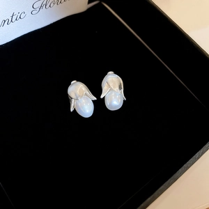 Dettaglio di orecchini a perla a forma di bocciolo con petali in argento opaco
