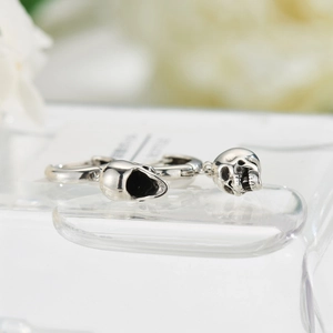 Macro shot of vintage silver skull pendant hoop earrings with antique finish