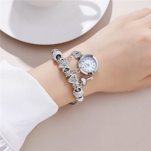 Silver beaded bracelet watch with heart, key, and starfish charms on female wrist