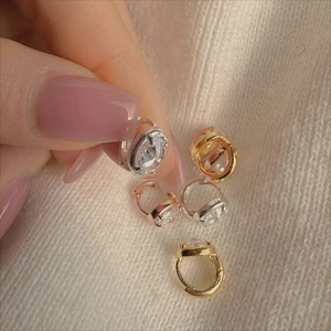 Detailed view of 925 silver huggie earrings in gold, silver, and rose gold finishes