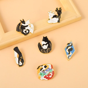 Détail de six broches animalières en émail avec motifs de dragon et de chat en noir et blanc
