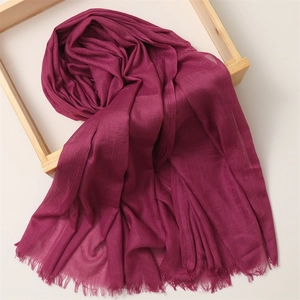 Detail view of fuchsia cotton linen scarf with soft texture and fringe edges on wood frame