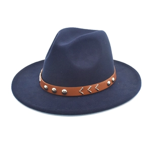 Detail of the navy blue wool fedora hat featuring a brown leather band and silver studs