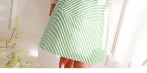 Detail of green and white striped apron showing durable cotton fabric and large utility pocket