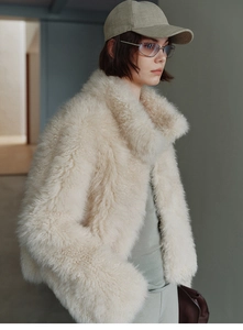 Close-up of fluffy faux fox fur vest in cream white with a soft plush texture