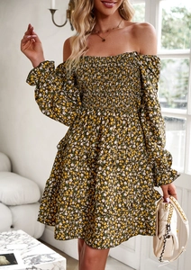 Detail of dark green floral dress featuring off-shoulder neckline and ruffled tiered hem