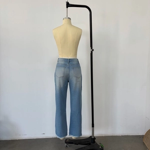 Détail d'un jean bleu clair montrant la taille haute et l'ourlet effiloché en vue arrière