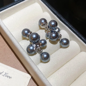 Close-up of French vintage grey pearl cluster earrings on a beige velvet jewelry box