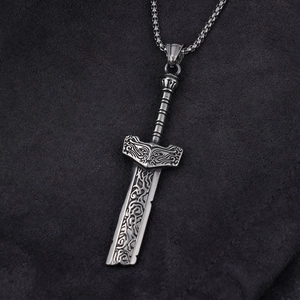 Vintage silver sword pendant necklace with Nordic reliefs on dark textured background