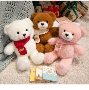 Detailed view of colorful plush bears with knit scarves and festive gift boxes