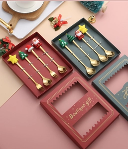 Close-up of golden stainless steel Christmas spoon and fork set in red holiday gift boxes