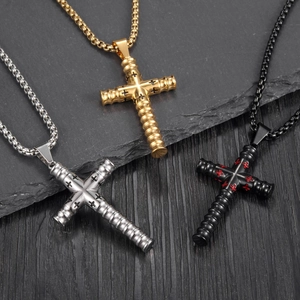 Colliers avec pendentif en croix en or, argent et noir sur fond de roche sombre