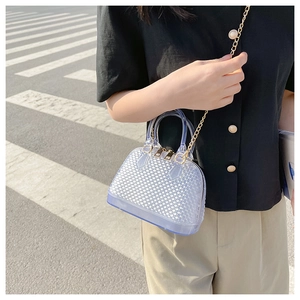 Transparent jelly handbag with honeycomb texture and gold chain strap shown on a model