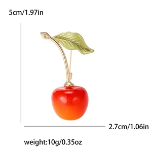 Cute cherry brooch with red resin fruit and golden metal stem on a white background