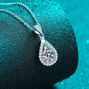 Elegant S925 sterling silver necklace with teardrop moissanite pendant on green background