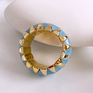 Macro shot of gold-plated bangle with blue marble triangle pattern on white stones