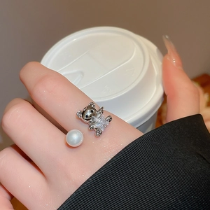 Detail of adjustable open ring featuring a zircon-studded bear and a white pearl accent