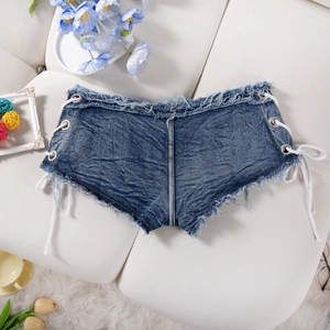 Dettaglio di pantaloncini di denim blu con lacci laterali e orlo a frange su base bianca