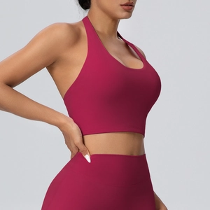 Dettaglio del reggiseno sportivo allacciato al collo rosa scuro e dei leggings a vita alta