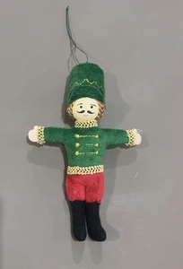 Detail of Nutcracker soldier fabric ornament with green jacket and gold trim