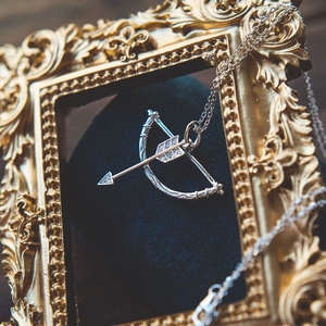 Elegant S925 silver cupid arrow pendant necklace with white zircon on blue velvet