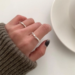 Detailed view of two 925 sterling silver rings with twisted line and wavy minimalist design