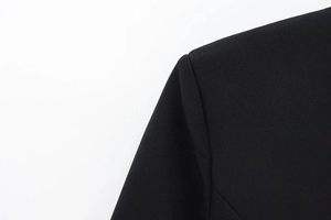 Close-up of the shoulder seam and sleeve texture on a black elegant V-neck blazer