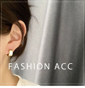 Close-up of minimalist gold titanium steel hoop earrings with white shell inlay on model