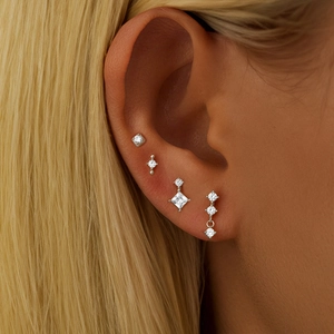 Close-up of S925 sterling silver ear studs set with zircon stones on model's ear