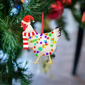 Detail of chicken Christmas ornament with Santa hat and scarf on festive holiday tree