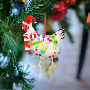 Detail of chicken Christmas ornament with Santa hat and scarf on festive holiday tree