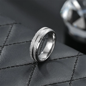 Macro shot of silver titanium steel ring with double-layered frosted texture and polished edge