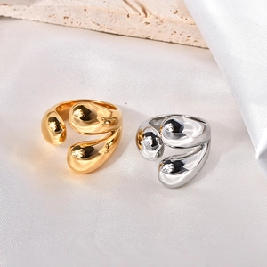 Minimalist gold and silver irregular water drop open rings on a stone background
