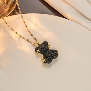 Detail of black resin bear pendant with gold star inlay on a stainless steel wave chain