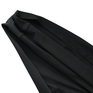 Close-up of black ruched dress fabric showing soft texture and quality stitching details