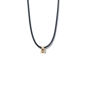Detail shot of a small golden heart pendant on a black cord necklace over white background