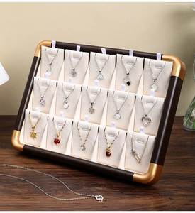 Detail of walnut-style jewelry tray with 15 hooks for gold and silver necklaces