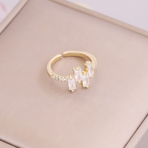 Close-up of 18K gold-plated ring featuring three rectangular zircons on a jewelry box