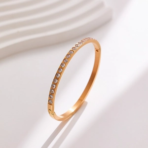 Rose gold titanium bangle with pavé crystals on white minimalist background