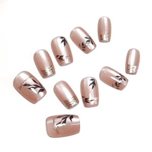 Nude pink cat-eye press-on nails with rose gold leaves and French gold glitter tips