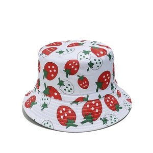 Detailed view of white cotton bucket hat featuring red strawberry and green leaf print