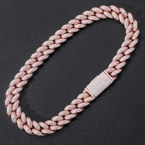 Macro shot of rose gold Miami Cuban link chain with zircon paving on a leather surface