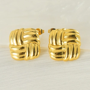 Detailed view of square twisted 18K gold stainless steel earrings on grey fabric