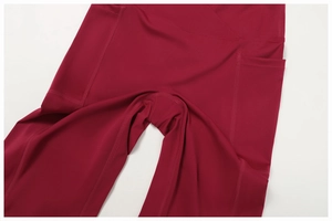Détail de la taille haute croisée en V et des poches sur le legging de yoga bordeaux