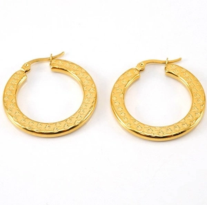 Detail showing gold hoop earrings with embossed star pattern and lever-back clasp