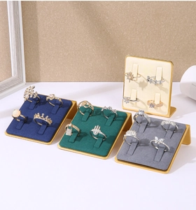 Detail view of four-slot ring display stands with velvet lining and gold metal frames