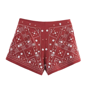 Gros plan des broderies florales géométriques sur un short rouge de style ethnique