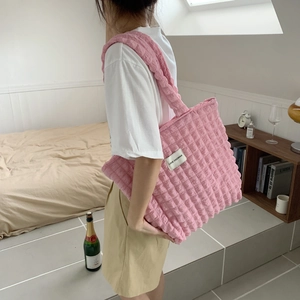 Dettaglio della borsa tote rosa con trama a bolle e l'etichetta tessuta sul tessuto