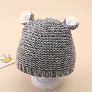 Macro detail of gray knitted baby hat with cute white bear ears and ribbed texture